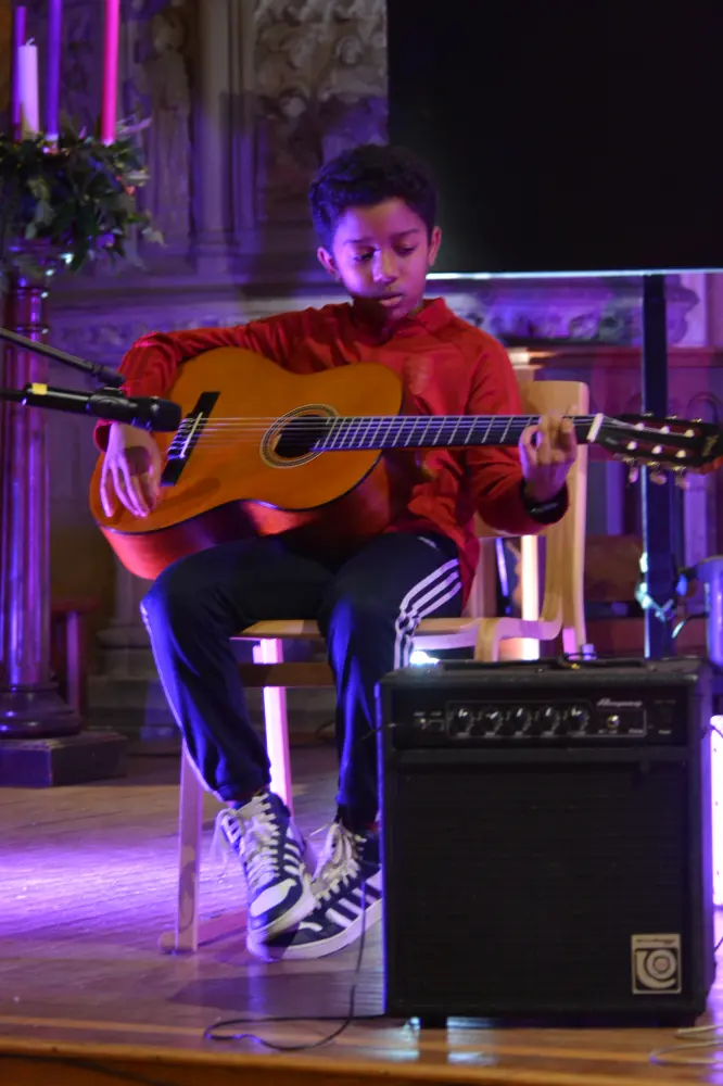A child performing on guitar
